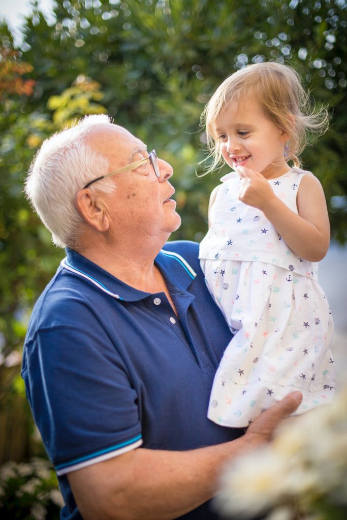 Senior holding up a young grandchild